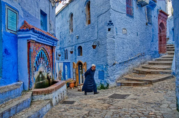 一个头戴头巾的人坐在五颜六色的历史村庄台阶上 Chefchaouen 摩洛哥 — 图库照片