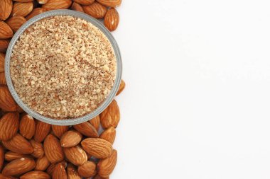 Beyaz arka planda bütün ve zemin çiğ badem.