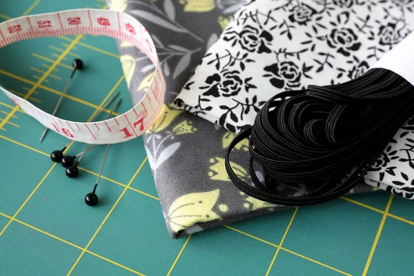 cotton sewing material with elastic, pins and measuring tape.