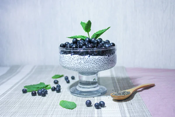 Chia tohumlu puding ve nane filizi ile süslenmiş sulu yaban mersini..