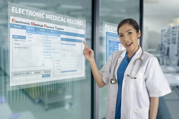 Kadın doktor şeffaf ekran cam Windows programında elektronik tıbbi kayıt sistemi tanıttı.