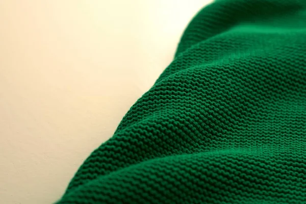 Green woollen sweater, texture detail close up.
