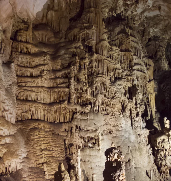 Yeraltı mağarasının büyük duvarı sarkıt ve dikitlerle kaplı, güzel bir doku ve tuhaf bir şekille kaplı.