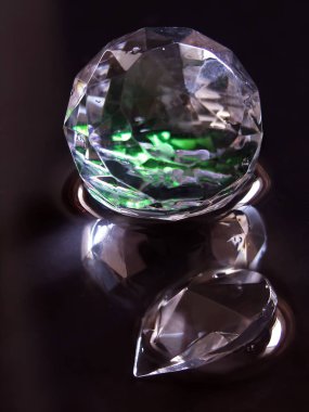 Siyah bir arka plan üzerinde bir su yüzeyinde yeşil kristal topu arkadan aydınlatmalı