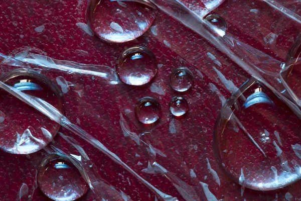 Tekstur Flydende Gennemsigtige Regndråber Placeret Den Røde Læder Baggrund Nærbillede - Stock-foto