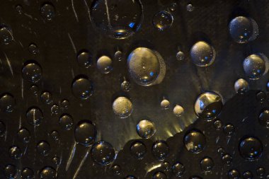 Siyah küreler siyah arkaplanda yer alır ve sarı-mavi ışık tarafından aydınlatılır. Kozmik soyutlama. 