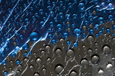 Koyu gri ve mavi sıvılar birbiriyle karışır ve parlak güneş ışınları tarafından aydınlatılır. Soyut fantezi. 