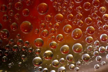 Farklı çaplara sahip kırmızı, gümüş ve altın küreler çok renkli arka planda yer alır. Kozmik soyutlama.