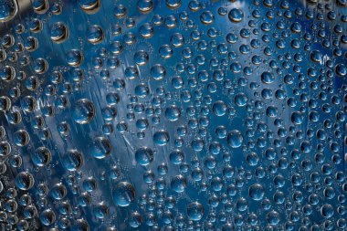 Turkuaz damlalar mavi ayna buz yüzeyine akar. Yakın plan..