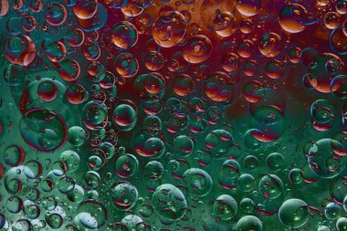 Kırmızı-yeşil arka planda yarı saydam yeşil ve kırmızı küreler bulunmaktadır. Soyut fantezi. 