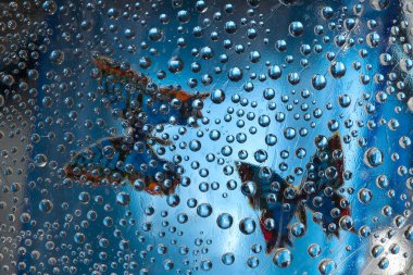 Şablon. Mavi metal küreler mavi arka planda kelebek siluetleri ile yer almaktadır. Soyut fantezi. 