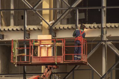 Elektrik kaynaklarını kullanarak binanın ön cephesini onarmak, işçiler için araba kaldırma teleskopu, artan güvenlik gereksinimleri