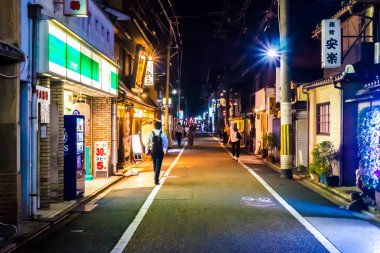 Kyoto 'da yürüyen insanlar: Geleneksel brasserie ve uygun mağazalar gece boyunca yol, Kyoto, Japonya 29-7-19