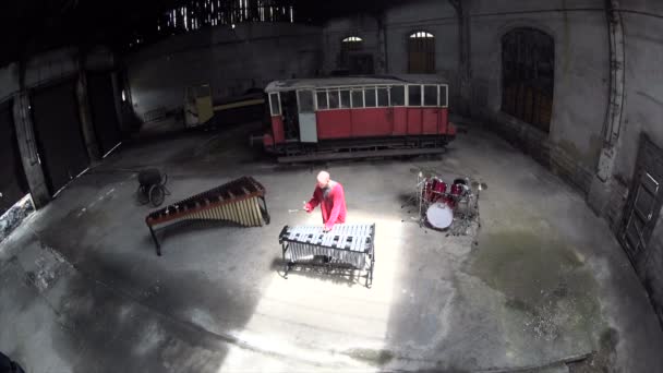 从空中观看男子在红色服装中扮演维邦人 旧火车修理厂 专业音乐中的音乐会感受 — 图库视频影像