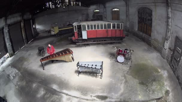 Aerial shot Uomo giocare la marimba in abito rosso - Vecchia fabbrica di riparazione treno — Video Stock