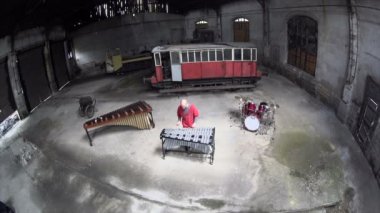 Hava fotoğrafçısı kırmızı kıyafetli vibratör çalıyor - eski tren tamir fabrikası