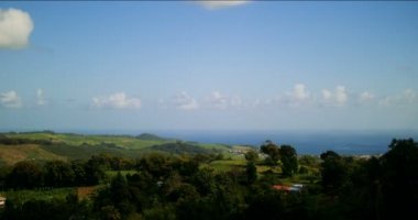 Martinique, Karayipler 'deki yüksek kontrastlı zamanlamalar. Mavi gökyüzü ve yeşil ağaçları olan güzel manzaranın aşırı hızlanması..