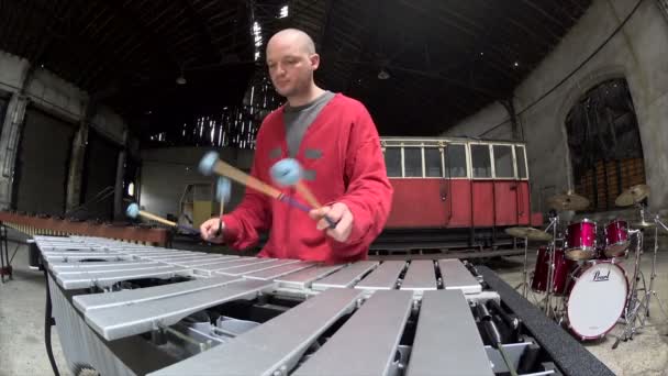 Fish eye view of stilig musiker spelar, Man spelar vibrafon i röd outfit - Gamla tåg reparationsfabrik — Stockvideo