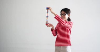 Güzel bir kadın yağmur çubuğuyla oynuyor. Küçük çakıl taşlarıyla dolu bir tüp. Çubuk altüst olduğunda, bu müzik aleti yağmuru hatırlatan bir ses çıkarıyor. profesyonel Uhd çekimi.