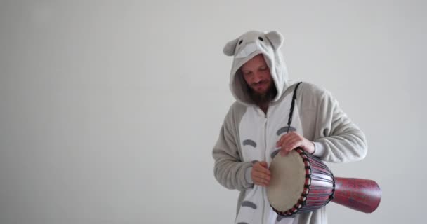 Músico guapo tocando el djembe, tambor africano con sus manos, vestido como un animal para la clase de educación artística musical. Profesional UHD media toma de loco divertido profesor . — Vídeo de stock