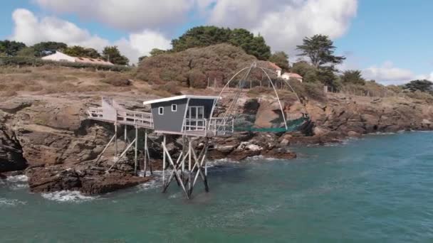 Beautiful drone shot of traditional french fisherman cabin on rocky cliff, blue sky with little clouds and green sea water pornic, france 1-9-19 — Stock Video