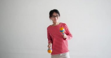 beautiful funny teacher playing and dancing with maracas. sometimes called rumba shaker, chac-chac is a rattle which appears in many genres of Caribbean and Latin music.