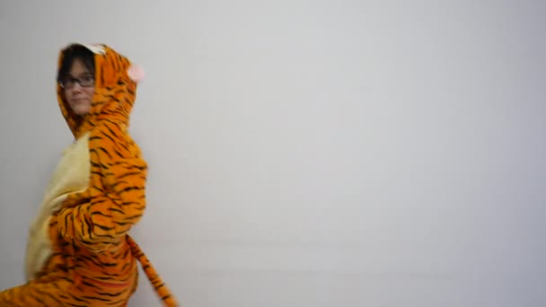 Mignon mince souriant asiatique femme chinoise dansant et souriant, cette danseuse attrayante porte un pyjama kigurumi tigre. fond blanc, sentiment heureux — Video