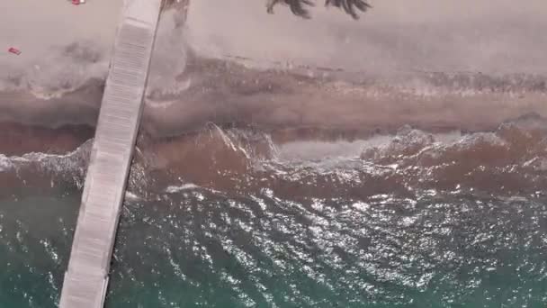 Schöne Aufnahme des Strandes von oben, gelber Sand mit grünen türkisfarbenen Meereswellen, paradiesischer Strand für erholsame Ferien. sonniger heißer Sommertag — Stockvideo