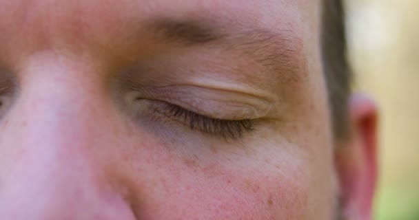 Vonzó férfi szemnyitás. Közelkép az ember kék szeméről. Tiszta és részletes kép. homályos háttér. Fényképezte: Cinema 4k (Uhd) kamera — Stock videók