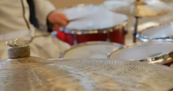 Detailní záběr mužských rukou hrajících na činely v červeném bubnu. profesionální bubeník hrající jazzovou hudbu v bílé košili a kalhotách. tělo bez hlavy — Stock video