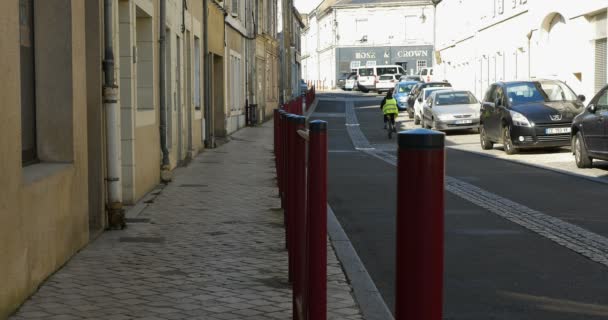 Vesnická silnice s cyklistou se žlutou vestou.in Le lude, Sarthe, Francie 27 / 2 / 19 — Stock video
