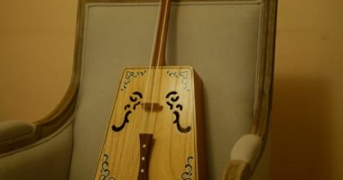 Morin Khuur 'un yakın çekimi, Ma Tout Qin olarak da bilinir, Çin Moğol geleneksel telli müzik enstrümanı. Gri, eski, sarı duvarlı bir koltuğa oturmuş güzel ahşap bir nesne.