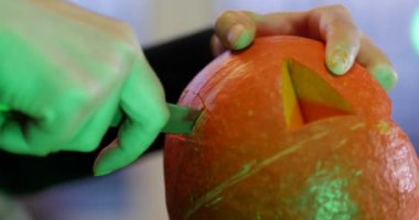 Cadılar Bayramı Feneri 'nin gözlerini ve burnunu oyan bir kadın. Yeşil korkunç ışıkla, perili eğlenceleri ve diğer korkunç eğlenceleri hazırlayalım. !