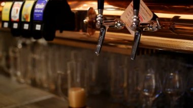 Avrupa İsviçre barında bira musluğu, gözlüklü ve bulanık arka planlı rahat bir alanın güzel renkleri