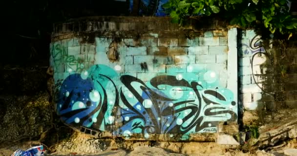 Grafiti-Malerei am Strand, französischer Straßenkünstler malte eine abstrakte Street Art an die Wand neben dem Meer und dem Sand, blau türkis und schwarz — Stockvideo