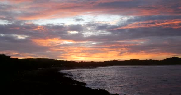 カラフルな豪華な紫色のピンクの曇りの映画的な風光明媚な空。ロマンチックなピンクの雲の夕日の海のパノラマ。フランスのエキゾチックなカリブ海の島で紫色の海の反射を持つダークホライズン｜Guadeloupe — ストック動画
