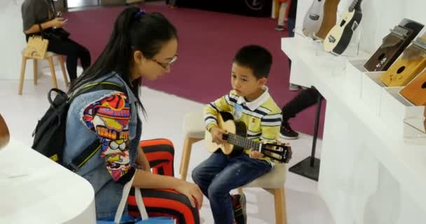 Čínský Chlapec Hraje Ukulele Svou Mámou Hudebním Veletrhu Číně Shanghai — Stock video