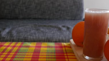 Tahta tabakta meyve tabağı ve meyve suyu gezintisi. portakal, limon greyfurt ve karpuz, bir sürü renk ve vitamin, Karayip stil masasında madras desenli sağlıklı yiyecekler..
