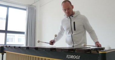 Marimba çalan perküsyon öğretmeninin yakın moda çekimi. Çocuklara ve öğrencilere müzik aletlerini tanıtmak. Gençler ne kadar çok eğitim alırsa, o kadar iyi olurlar. Mans, Fransa 1-1-19