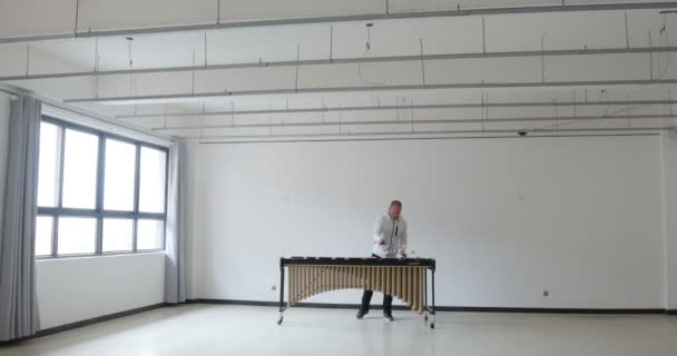 Mann Spielt Marimba Weißem Outfit Einem Leeren Raum Mit Fenstern — Stockvideo