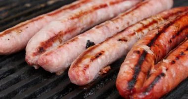 Izgara sosis ve açık havada ızgara tabağında sebze ve şifalı otlar. Izgara yemek, bbq, barbekü nefis yaz barbeküsü ateşin üzerinde sosisle ızgara yapıyor..