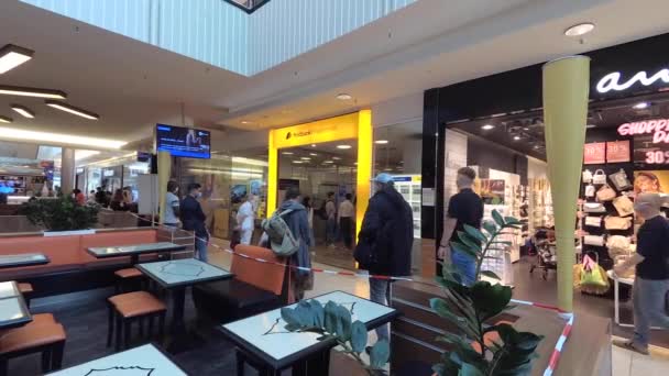 Handheld shot for news: field reporter style: people waiting in front of German Postbank shop store front in Mall Hannover, Germany, 31.8.2019 — Wideo stockowe