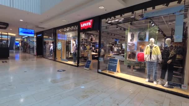 Tiro de mano para noticias: estilo reportero de campo: Levi 's shop front in Mall in Hannover, Germany, 31.8.2020 Levis es una famosa marca americana de jeans y pantalones. — Vídeo de stock