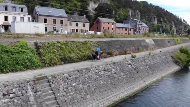 Cyklista v modré košili, na projížďce na kole, silnice mezi řekou a vlakem. Létání za cyklisty, Letecký dron záběr cyklisty jezdit krásné epické nastavení krajiny — Stock video