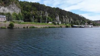 Arka planda nehir ve trenin insansız hava aracı görüntüsü, kargo vagonlu yük treni orman dağlarındaki nehir kenarındaki Sibirya demiryollarının oluşturduğu elektrikli lokomotif.