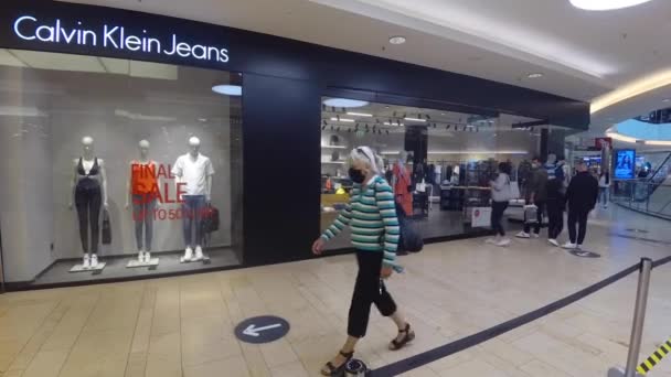 Haberler için el kamerası görüntüsü: saha muhabiri tarzı: CALVIN KLEIN JEANS mağaza önü Hannover, Almanya 'da AVM, 31.8.2020 CK ünlü bir kot, gömlek ve lüks giysi markasıdır. — Stok video