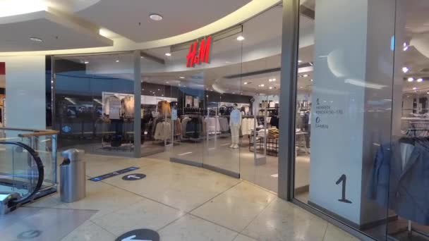 Haberler için el kamerası görüntüsü: Saha muhabiri tarzı: H & M mağaza önü Almanya 'nın Hannover kentinde, 31.8.2020 HM, ünlü erkek ve kadın giyimi markası. — Stok video