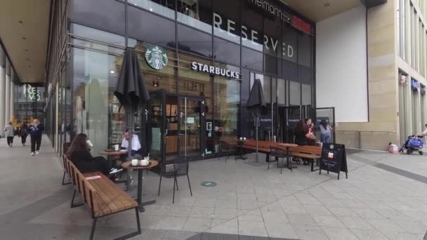 Tiro de mano para noticias: estilo reportero de campo: tienda de STARBUCKS frente al centro comercial en Hannover, Alemania, 31.8.2020 Starbucks es una famosa marca de cafeterías — Vídeo de stock