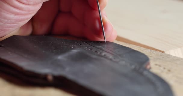 Lederhandwerker Lochung in Handarbeit, Lederwaren handgefertigte und handgenähte Accessoires wie Lederbrieftasche oder Schuhe sind beliebte Lederwaren, Mann macht handgemachte Lederwaren Mode — Stockvideo