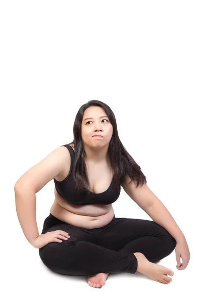 Fet kvinna feta magen sitter på marken uttråkad ansikte trött utmattad att utöva viktminskning konceptet isolerade på vit bakgrund — Stockfoto